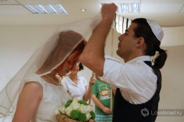 По традиции жених покрывает лицо невесты фатой.