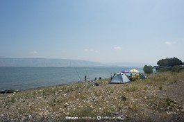 Люди ставят палатки на озере Кинерет.