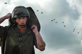 Парашютист с парашютом на учениях.